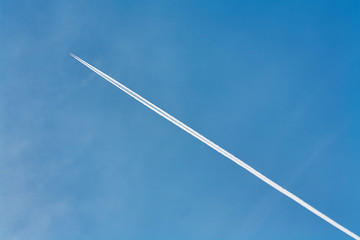 Trace of an airplane against blue sky.