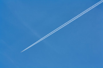 Trace of an airplane against blue sky.