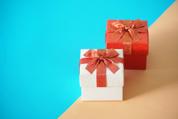Red and white gift boxes on blur and brown background, picture have space for idea.