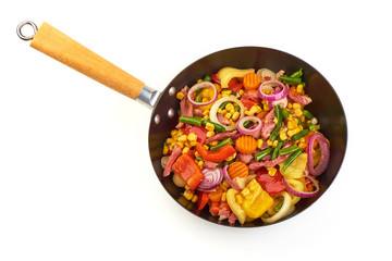 Fried vegetables in a frying pan, isolated on white background