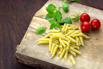 pasta,tomatoes,basil on a wooden cutting board