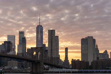 View of Manhattan skyline and Brooklyn bridge at sunset