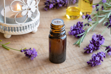 Fototapeta na wymiar A bottle of lavender essential oil with fresh blooming lavender