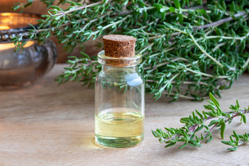 A bottle of thyme essential oil with fresh thyme