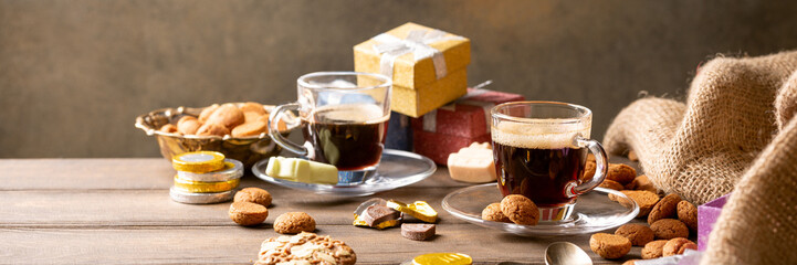 st. Nicolas day concept. Dutch holiday Sinterklaas, festive breakfast with coffee, kruidnoten, traditional sweets and presents. Copy space. Banner.
