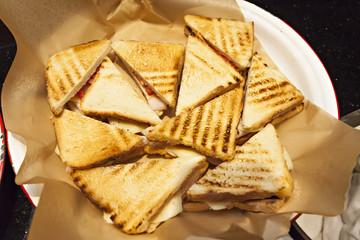 Toasted club panini sandwiches with ham, cheese and tomato