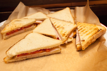 Toasted club panini sandwiches with ham, cheese and tomato