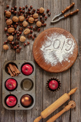 Christmas  background with red apples, walnuts, hazelnut, nutcracker, cinnamon and red candles.