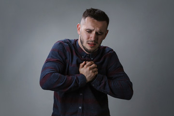 Man having chest pain - heart attack, on grey background