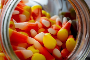 Halloween theme featuring a spilling of candy corn from a jar not a wooden table.