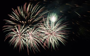 green and silver colored fireworks, multicolour festive fireworks in night sky