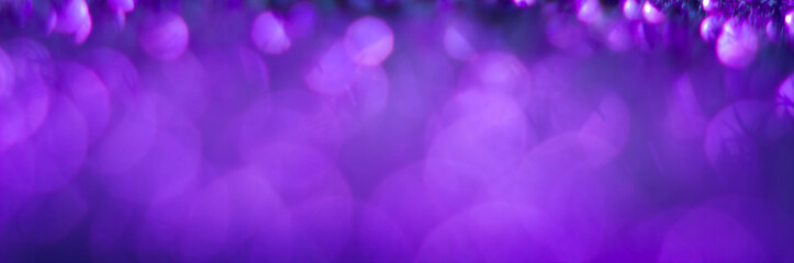 Violet bokeh on a black background. Defocused. Abstract background for your design. Free space for text.