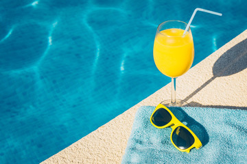 Sunglasses and a glass of orange juice in the resort hotel