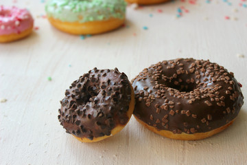 Doughnut in chocolate icing white textured background close-up, top view