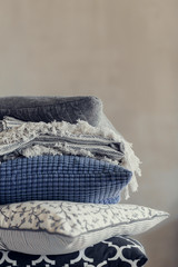 pile of pillows on the edge of the bed, in gray, monochrome