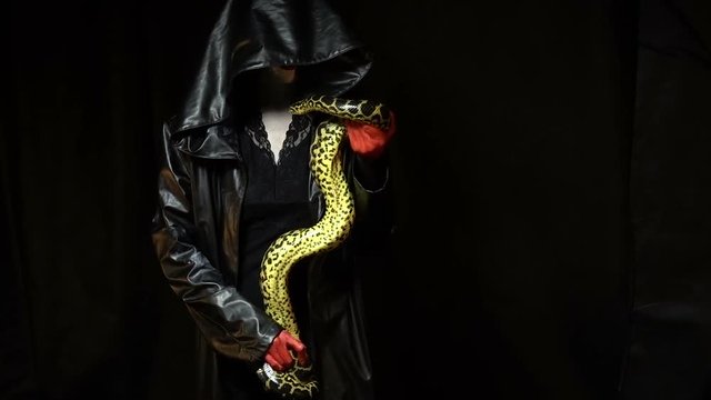 Woman in black coat with python