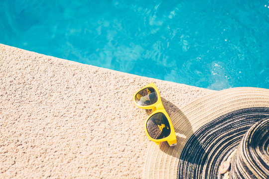 Sunglasses and hat on the poolside - girl on vacation