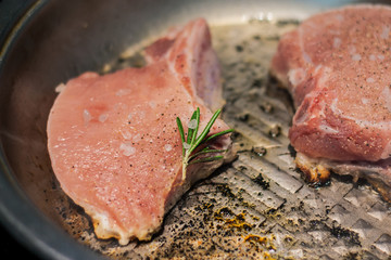 The cook fries a pork loin in a frying pan with spices