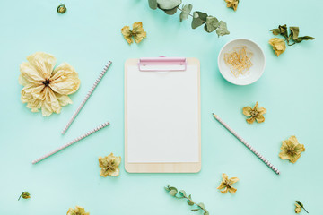 Flat lay home office desk workspace with space for text  on blue background. Minimal mock up with view from above.