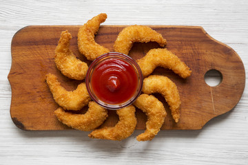 Fried shrimps tempura with sauce on wooden board over white wooden background, top view. Close-up.