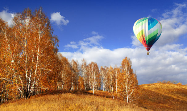 Fototapeta Balloons start fly on forest, hills in autumn