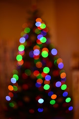 Multicolored blurred silhouette christmas tree bokeh. Abstract background