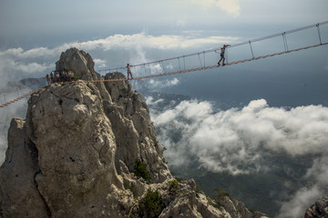 Tourist walking on rope bridge on the Mount Ai-Petri, Crimea