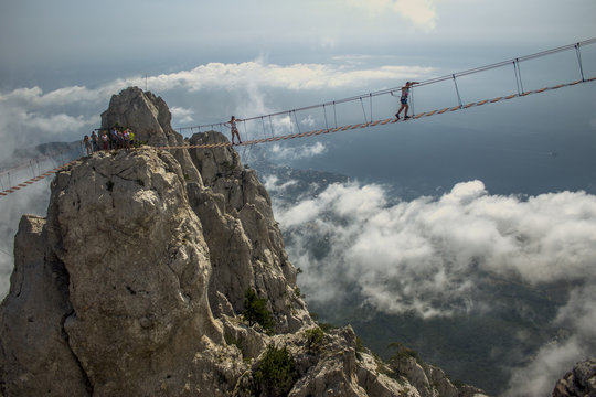 Fototapeta Tourist walking on rope bridge on the Mount Ai-Petri, Crimea