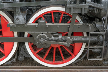 large red-white steam locomotive wheels.