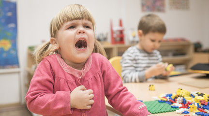 Little caucasian girl crying in kindergarten