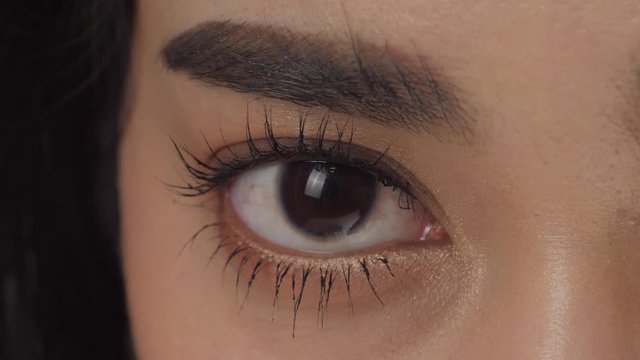 Macro Close up shot on eye of young asian woman with natural makeup in slow motion.