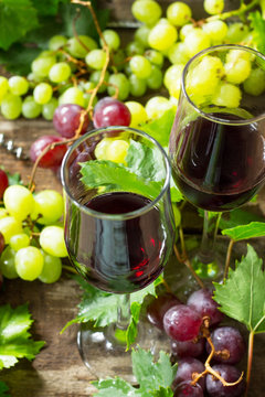 Wine background. Red wine in glasses, bottle, grapes on vintage background, wine concept.