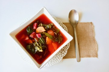 Tasty pink beet kale soup in the white bowl.
