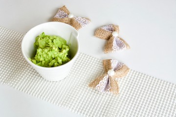 Tasty green avocado coconut sauce in the white bowl.