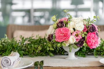 Neatly twisted into a tube dining room napkin decorated with a sprig of pistachio. Wedding Banquet or gala dinner. The chairs and table for guests, served with cutlery and crockery. party on terrace