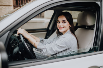 Beautiful Smiling woman driving car. attractive girl sitting in automobile