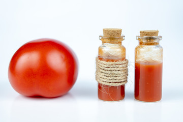 Tasty juice from ripe tomatoes in a small bottle. A healthy and nutritious drink with lots of vitamins.