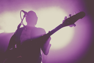 Silhouette of an unregnizable bass guitar player