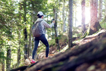 Active female hiker walking and exploring forest