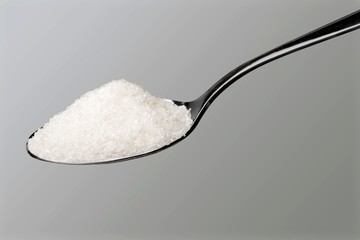 Spoon full of salt on white background