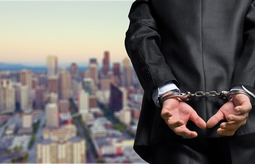 Cropped image of male hands in handcuffs behind his back