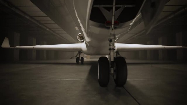 White private jet revealed by lighting inside a hangar