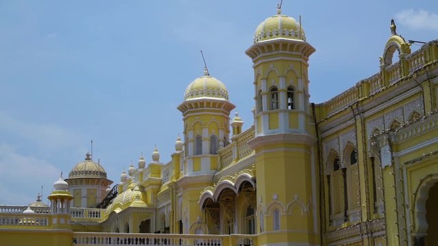 Two bright yellow towers stretching out from a bright yellow wall in India.