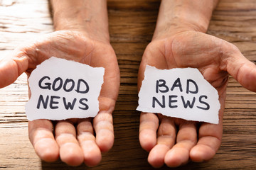 Man Showing Paper With Good And Bad News - obrazy, fototapety, plakaty