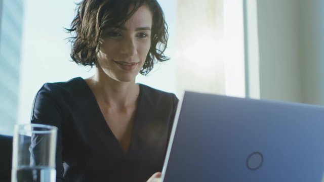 Portrait of the Focused Female CEO Working on a Laptop. Happy Successful Businesswoman Doing Her Important Business Job Beautifully.
