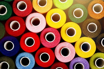 Spools of colorful thread, different colors background