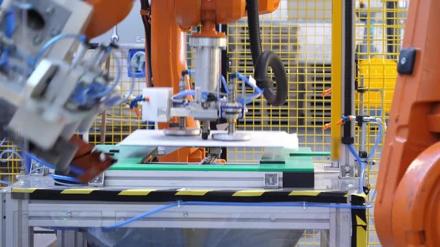 Robotic arm lifting glass surfaces in a modern factory