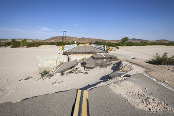 Washed out flood damaged highway road and bridge in the Mojave desert near Barstow, California.  