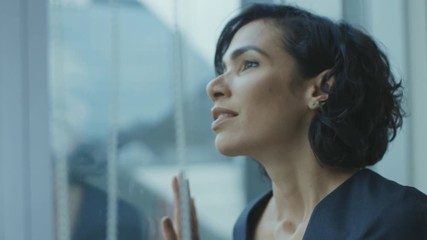 Close-up Portrait of the Beautiful Young Businesswoman Looking Thoughtfully out of Her Office Window
