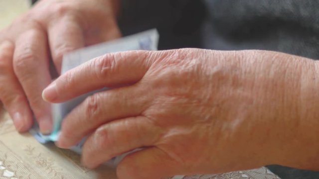 Old woman counting euro banknotes closeup, selective focus